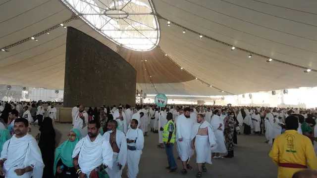 Pilgrims in front of a pillar inside the Jamarat Bridge